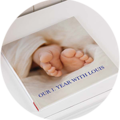 Een open fotoboek met een foto van babyvoetjes en de titel 'Ons jaar met Louis'.